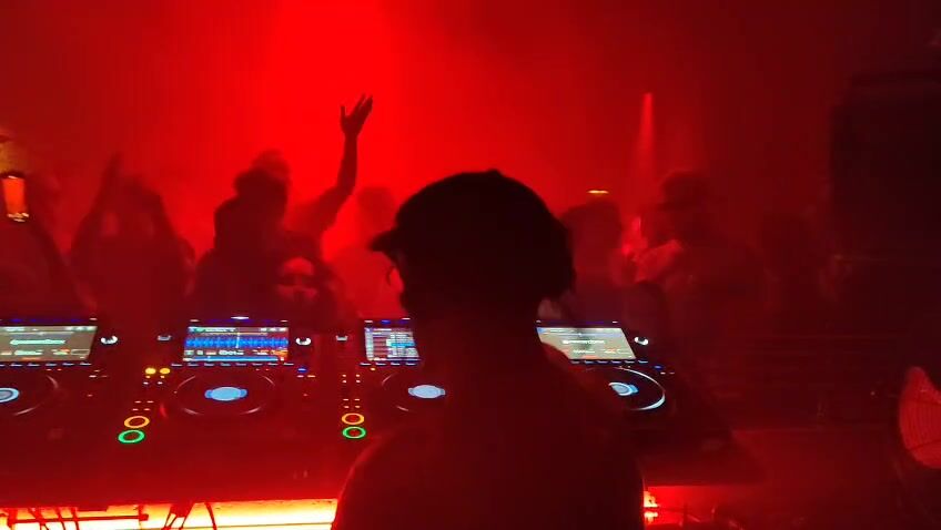 Theon Bower at the decks at fabric, seen from behind, crowd with hands up under red light